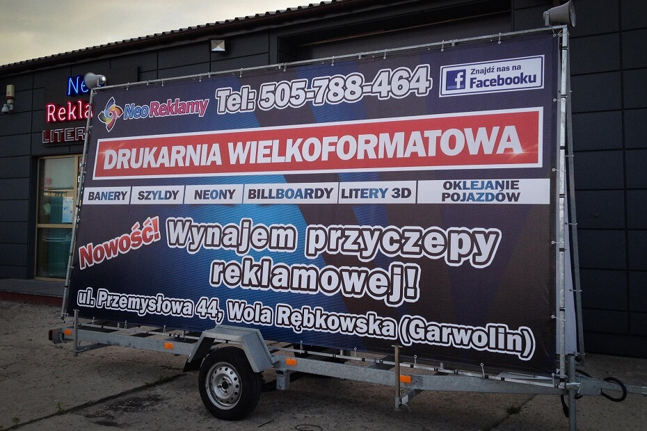 Przyczepa reklamowa ustawiona przy trasie